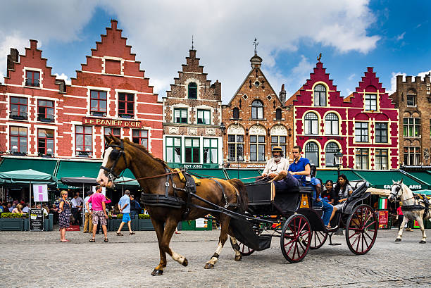 Bruges, Belgium - August 7, 2014: Image of horse-drawn carriage with tourists in Grote Markt,  Brugge, Flanders in Belgium.
