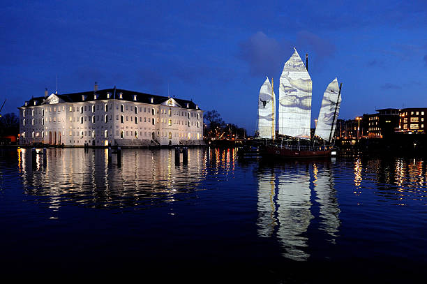 Amsterdam, The Netherlands - December 19, 2013: Dutch National Maritime Museum at night with, on the right side, an art object of the Amsterdam Light Festival 2013.