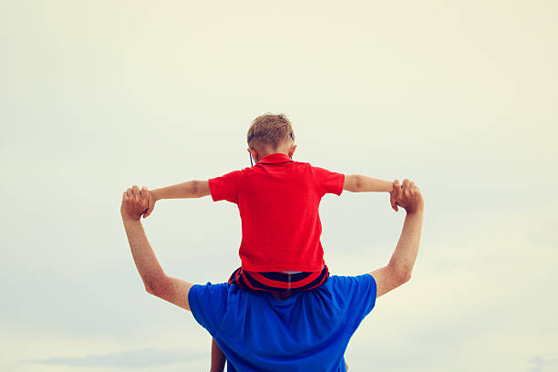 istock father and little son on shoulders play at sky 510223568