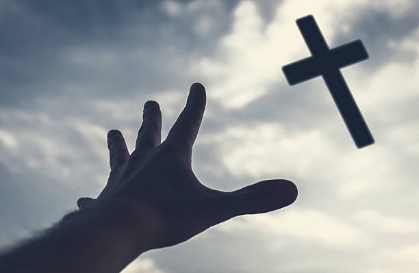 istock Hand reaching to the cross in the sky. 510224607