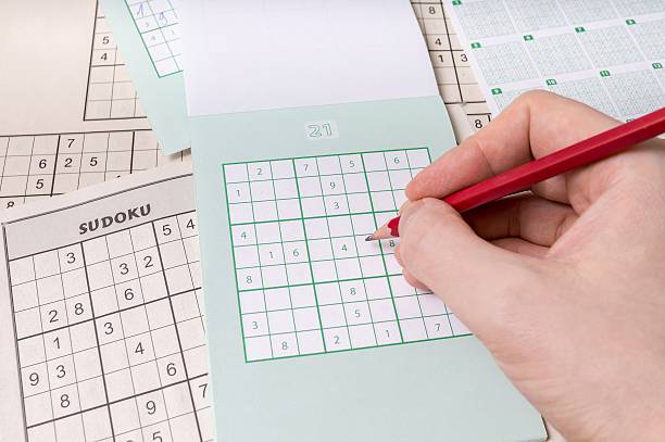 istock Hand is holding pencil and is solving sudoku crossword 510225468