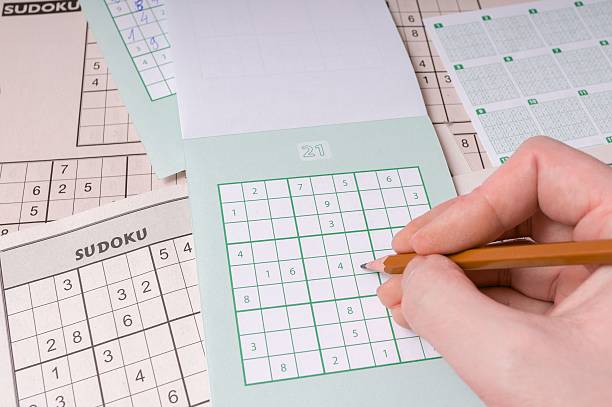 istock Popular brain teaser logic game sudoku. Hand is writing numbers 510225514