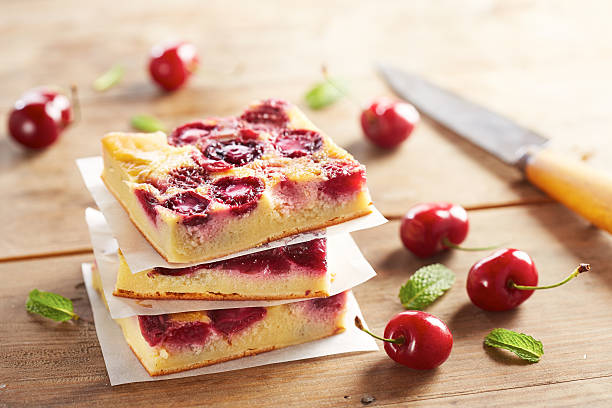 Cherry clafoutis pie on wooden table Cherry clafoutis pie portions stacked on wooden table clafoutis stock pictures, royalty-free photos & images
