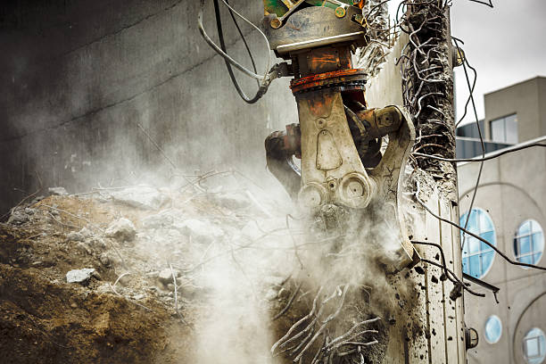 istock Demolition excavator takes down concrete wall 510226978