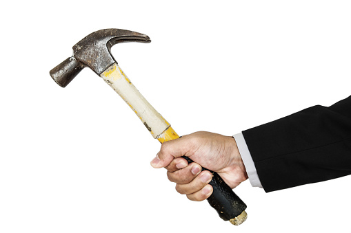 Businessman's hand holding old hammer, isolated on white background