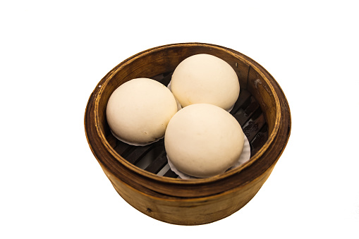 Chinese dim sum 'steamed buns' in bamboo basket isolated on white background