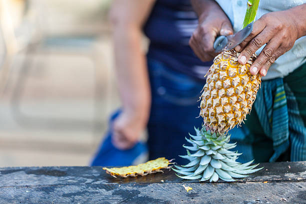 istock Man cut a pineapple for tourists 510228830