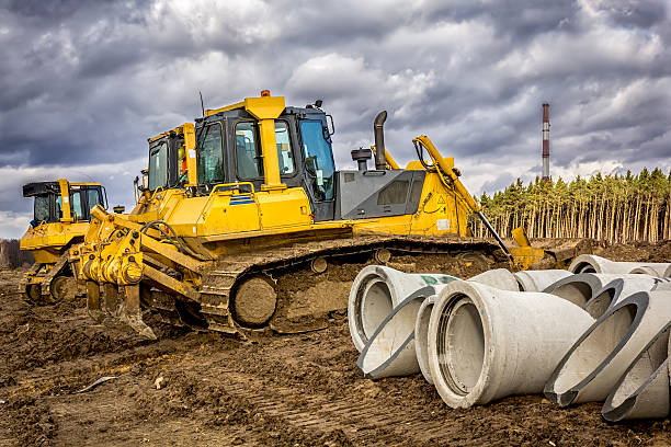 istock Concrete drainage pipes and bulldozers 510229612