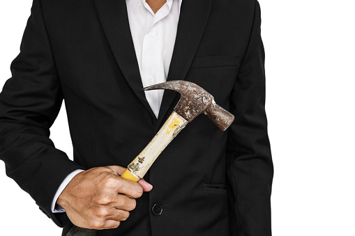 Businessman holding old hammer, isolated on white background