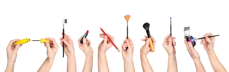 collection of hands holding tools for makeup isolated on white background