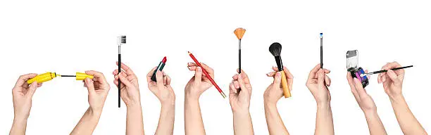Photo of collection of hands holding tools for makeup