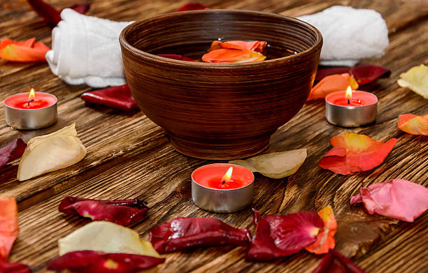 istock Spa composition with rose petals and candle in clay bowl 510235384