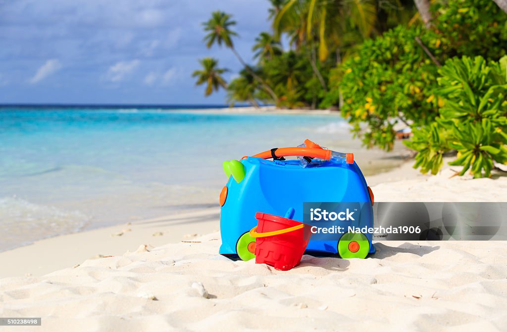 kids suitcase, toys and snorkel equipment at beach kids suitcase, toys and snorkel equipment at beach, family vacation Bag Stock Photo