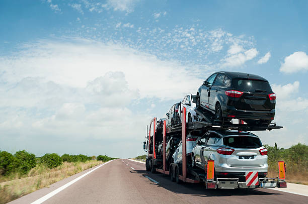 Articulated truck transport of automobiles driving on the road.