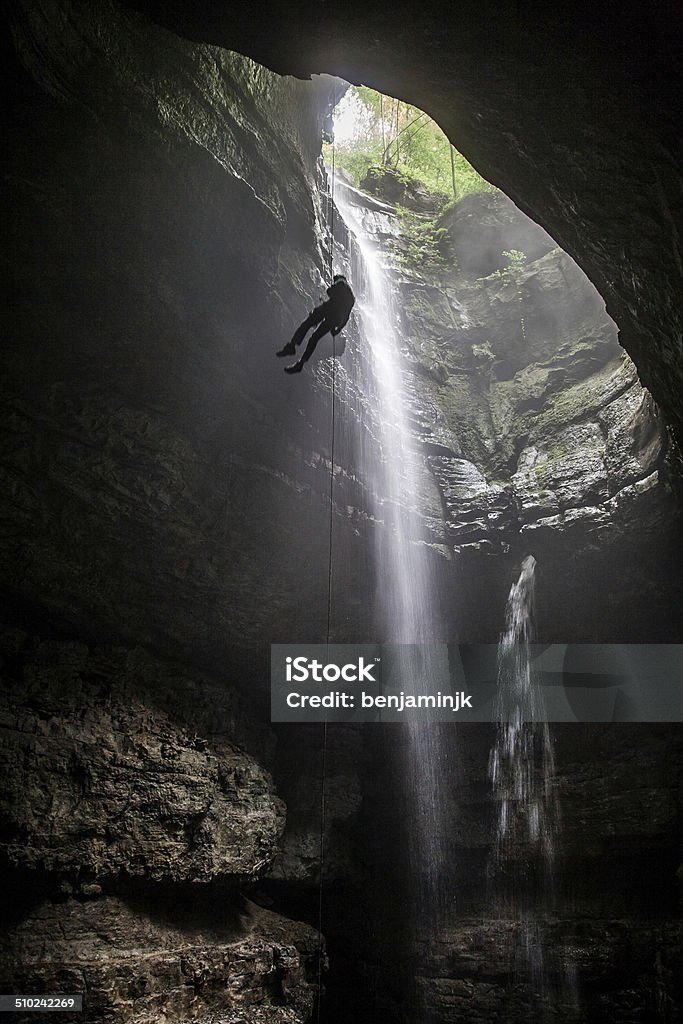 Thread the needle A caver rappels into Stephen's Gap, a large pit cave in Alabama. Spelunking Stock Photo