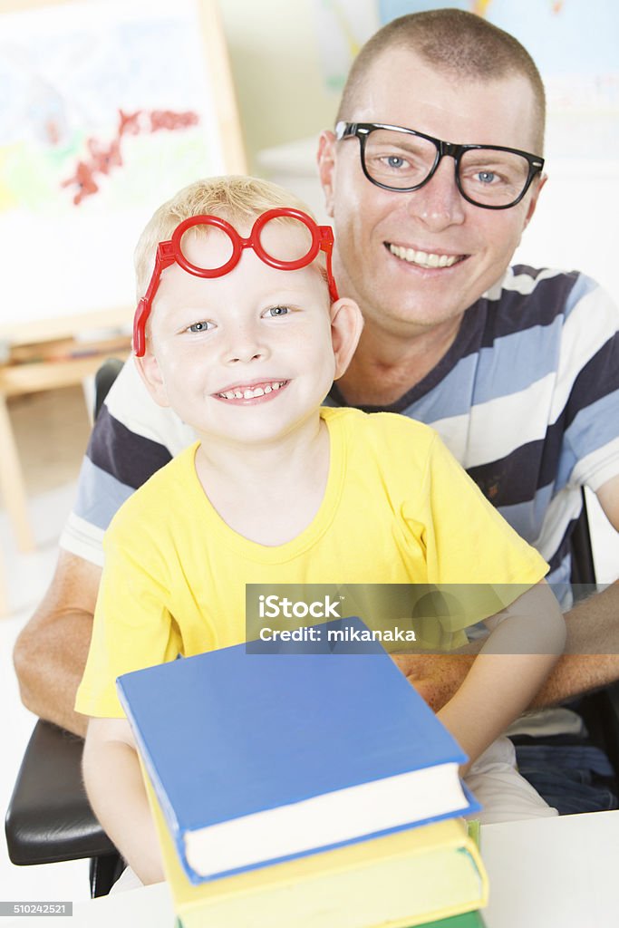 Disable father reading with little son. Disable father and his little son reading a book together. 4-5 Years Stock Photo