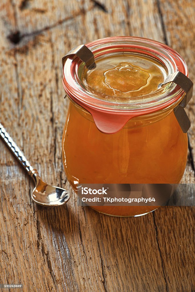 Melon jam in preserving jar with a spoon Homemade melon jam in a preserving jar with a spoon on old wooden table Boiled Stock Photo