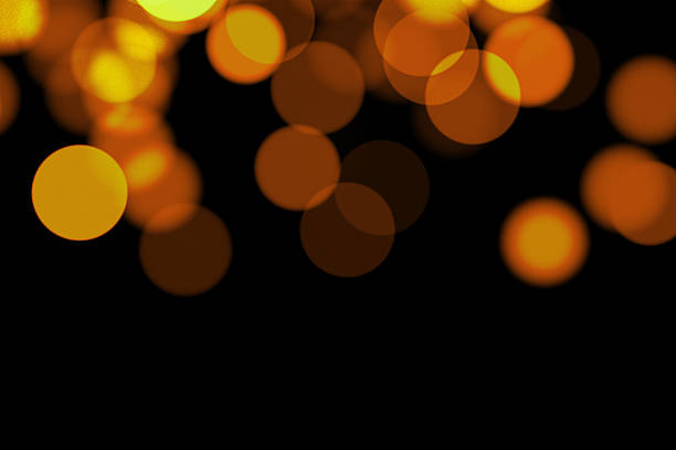 High resolution image of warm tone blurred dots on black background with copy space