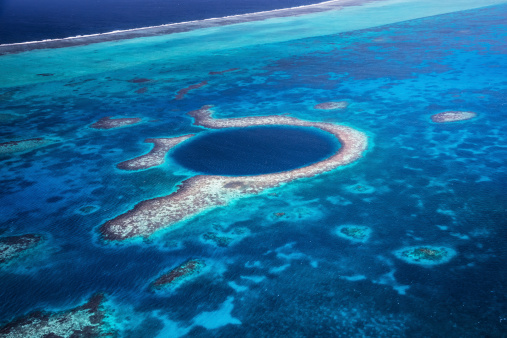 Aerial view down to the famous diving site and natural phenomenon the Blue Hole in the Lighthouse Reef, East of the Turneffe Atoll in Caribbean Sea, Belize, Central America.