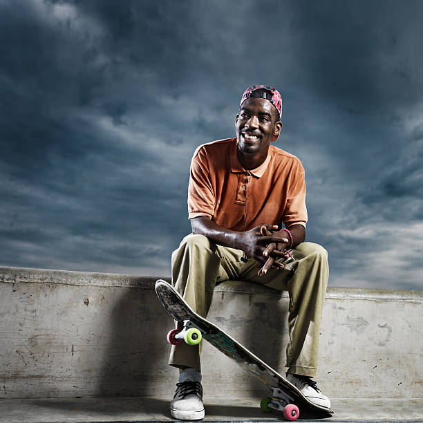 istock cool african skate boarder sitting down to rest 510270485