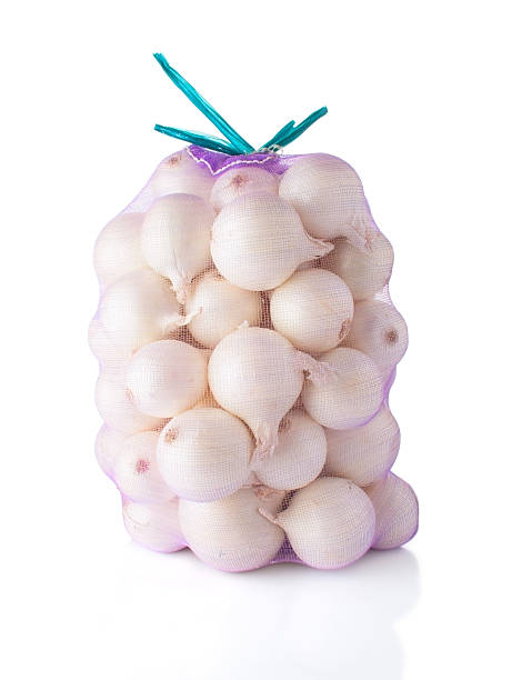 sac complet avec des oignons blancs - onion bag netting vegetable photos et images de collection