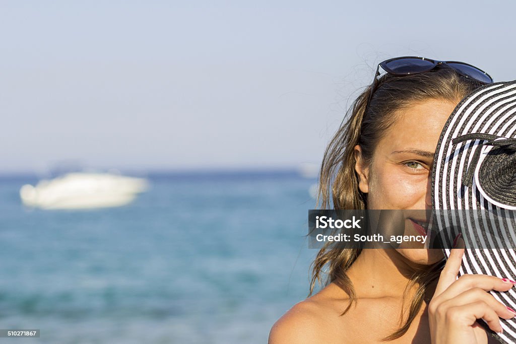 Sunny portrait of a young brunette relaxing at the beach Sunny portrait of a young brunette relaxing at the beach. Adult Stock Photo