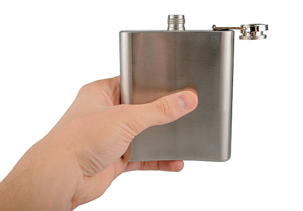 istock Male hand holding stainless hip flask isolated on a white 510286729