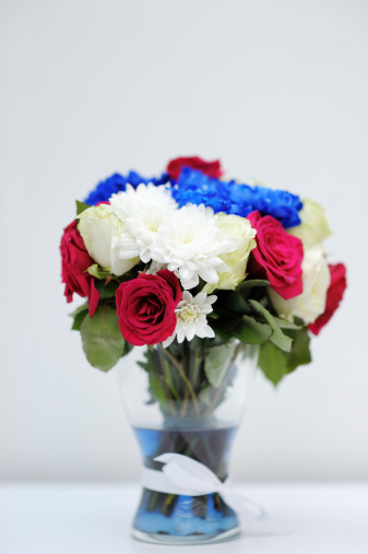 Bright blue and red bouquet on glass vase