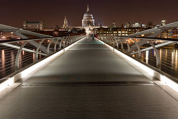 St. Paul's Cathedral e o Millennium Bridge à noite - foto de acervo