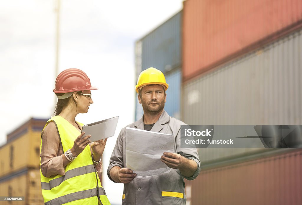 Workers in large commercial container dock Adult Stock Photo