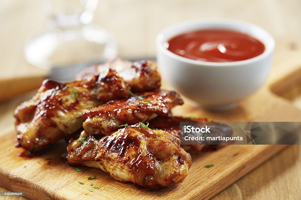 Chicken wings with sriracha sauce Chicken wings with sriracha sauce on wooden table Chicken Wing Stock Photo