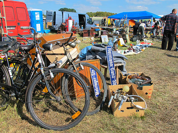 Havelberg, Germany - September 3, 2014: Cardboard boxes for sale are filled up with bikes and street name signs. Bike on the left side. People walking by and looking on the other stands too. Its part of the flea market takes place at Havelberg (Saxony-Anhalt, Germany) every year at first September week. 