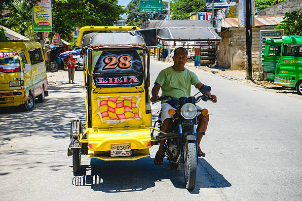 Tricycle in Cebu, Philippines Cebu, Philippines - April 16, 2015: A colorful tricycle and its driver in a street in Cebu, Philippines philippines tricycle stock pictures, royalty-free photos & images