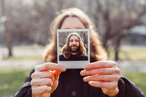 istock Man holding an instant selfie 510303214
