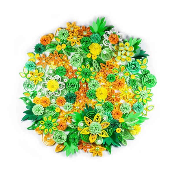 Closeup of yellow, green, orange and white paper quilling flowers Closeup of yellow, green, orange and white paper quilling flowers arranged in circle isolated on white background paper quilling stock pictures, royalty-free photos & images