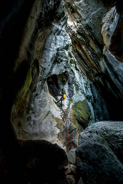 istock Rappeling down the rock in the cave 510303714