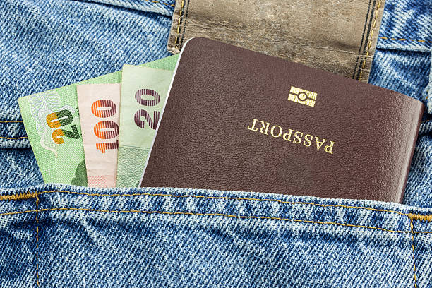 Money and passport in blue denim jeans Closeup of money and passport in blue denim jeans pocket jeans denim passport pocket stock pictures, royalty-free photos & images