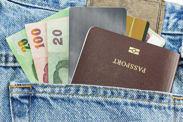 Money credit card and passport in blue denim jeans Closeup of money credit card and passport in blue denim jeans pocket jeans denim passport pocket stock pictures, royalty-free photos & images