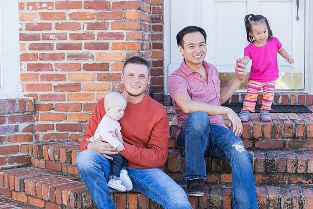 istock Two fathers with their young children sitting on steps 510308252