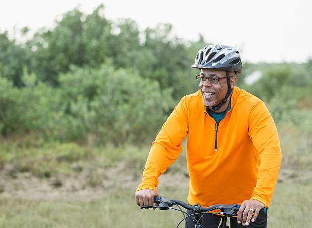 bicicleta de hombre del afroamericano montar a caballo en el parque - african descent cycling men bicycle fotografías e imágenes de stock