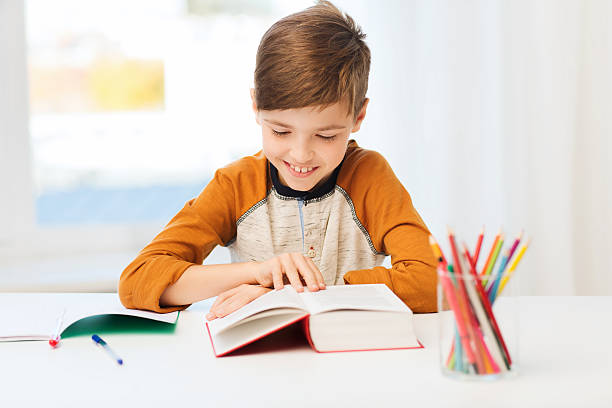 istock smiling, student boy reading book at home 510309592