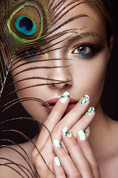 hermosa chica con manicura de diseño y pluma pavo real - stage makeup peacock make up feather fotografías e imágenes de stock