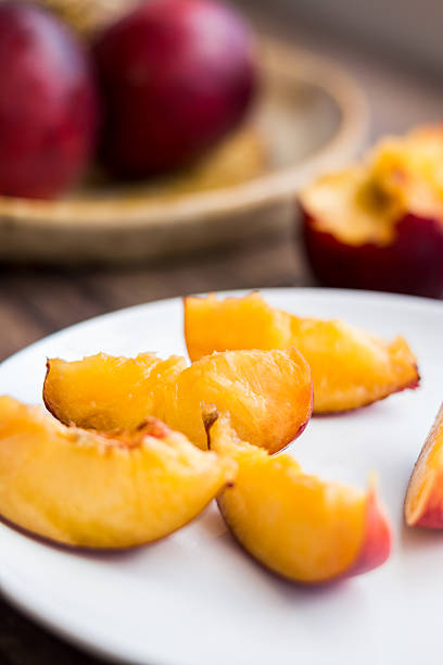 istock bright peach slices on white round plate, close up 510309807