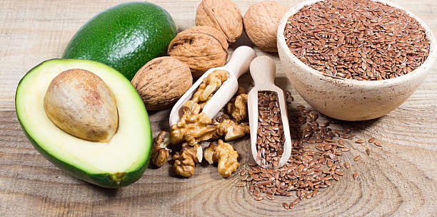 Sources of omega 3 fatty acids: flaxseeds, avocado and walnuts stock photo
