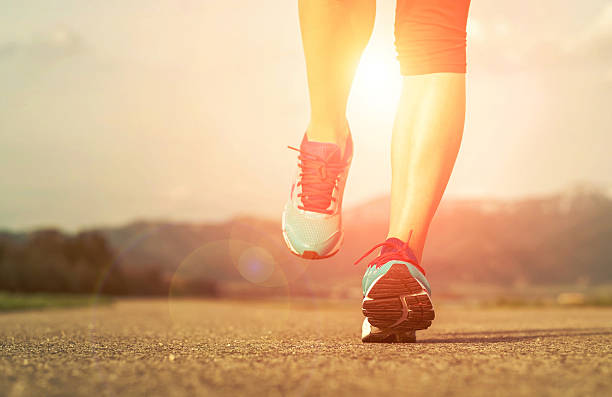 istock Runner athlete feet running on road under sunlight. 510316908