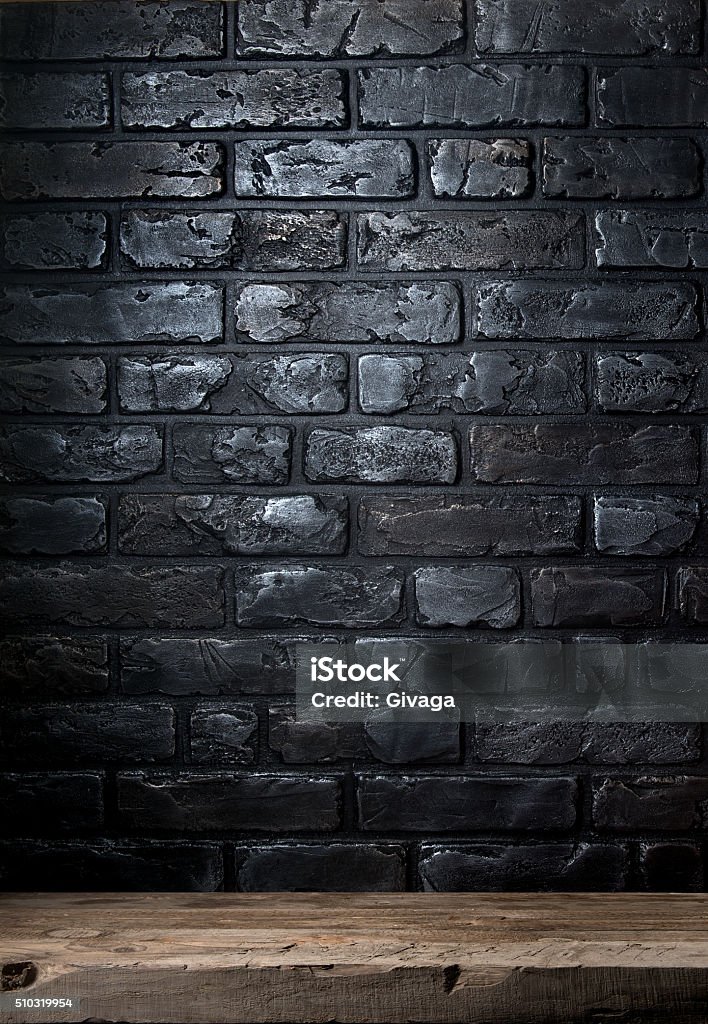 Brick wall and table Black brick wall and old wooden table Black Color Stock Photo