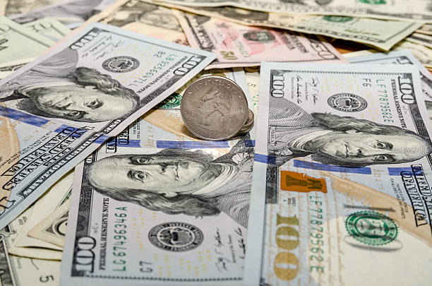 istock Quarter dollar coin and One  Hundred Dollar banknotes currency 510326536
