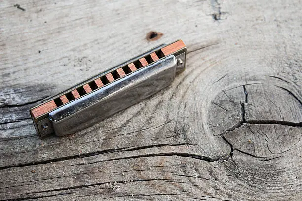 Blues harmonica on a wooden board background