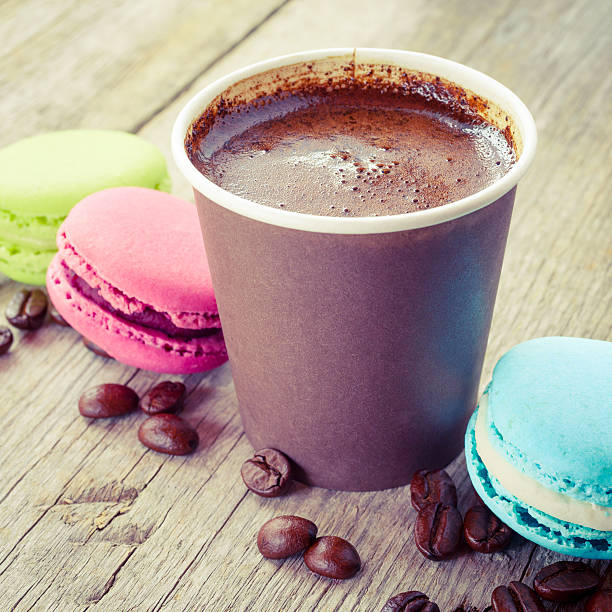 macaroons and espresso coffee cup on old wooden rustic table, vintage stylized photo