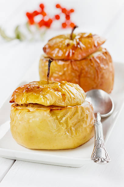 pommes au four avec du miel, curds, raisins secs et noix - baked apple food meal dessert photos et images de collection